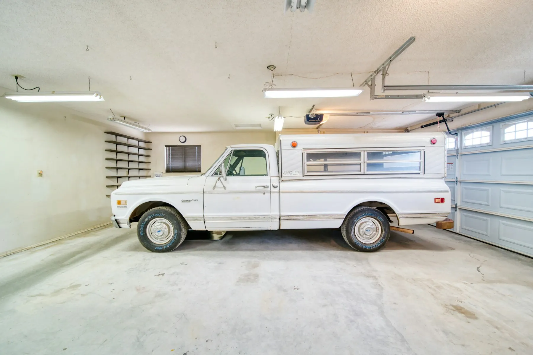 Garage interior with the opener rail and door track above a parked pickup